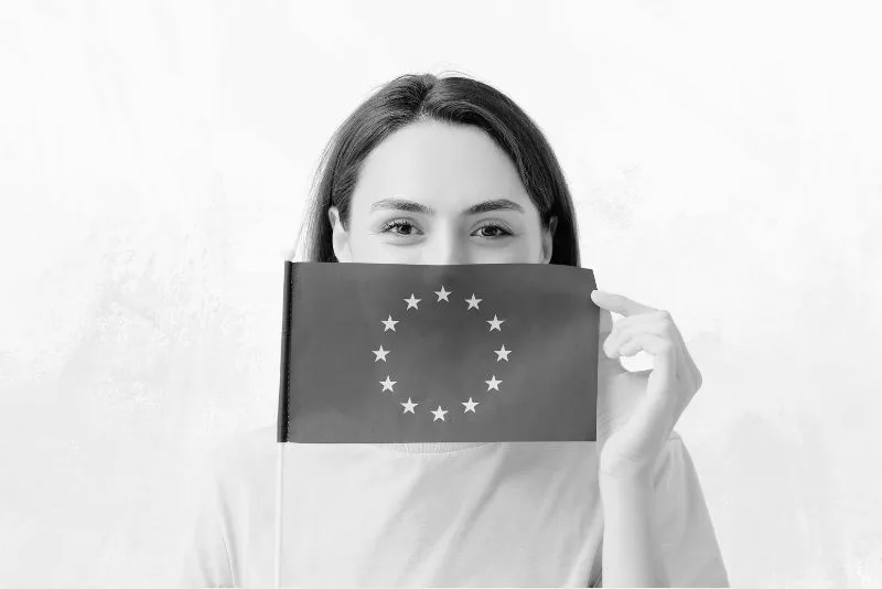Une femme avec le drapeau Européeen illustrant un article sur le Réglement Général d'Exemption par Catégorie (RGEC)